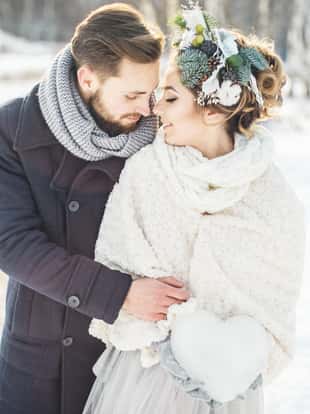 The groom embraces the bride. Beautiful young couple in a Park in winter.