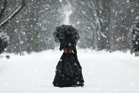 Mysterious lonely woman in Victorian dress departing into the distance