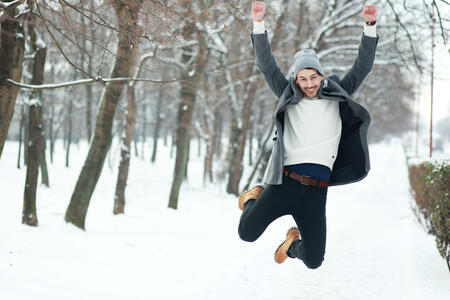 happy young man on winter park jumping have joy