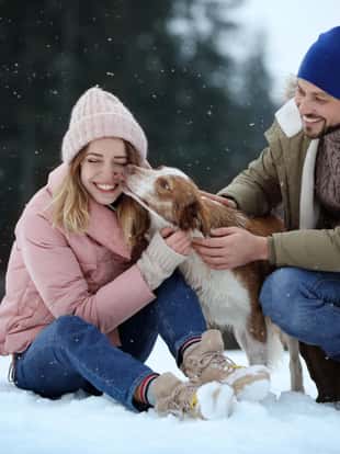 Cute couple with dog near forest. Winter vacation