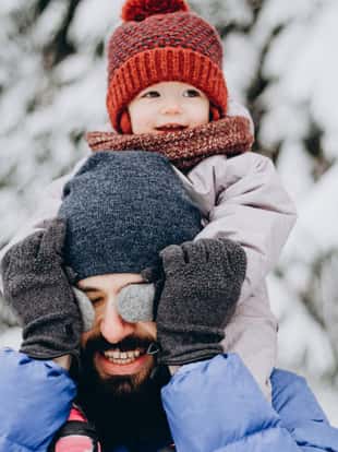 Happy loving family! Father and his baby are playing and hugging outdoors. Cute little child and daddy on snowy winter walk in nature. Concept of frost winter season.