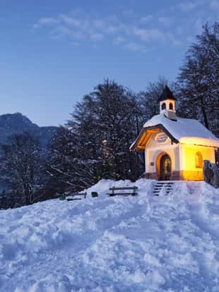 Chapel at Lockstein in Berchtesgaden at sunset with Christmas tree in front of mountain, Germany.