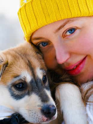 Woman with Husky puppy family dog in winter Rovaniemi of Finland of Lapland. Lady in Norway. Girl at Animal on Finnish farm, Christmas. Sleigh. Safari on sledge with landscape