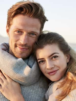 Portrait Of Loving Couple Walking Along Winter Beach Together