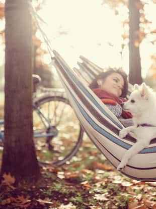 Woman with her dog relaxing in the autumn park