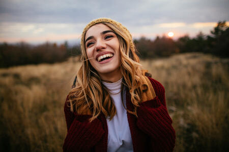 Portrait of young, smiling girl enjoying nature in a twilight