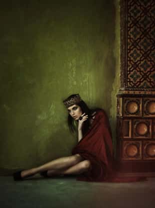 Young attractive girl in the image of Russian princess in rich interior. Grain added