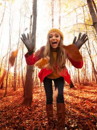 Young woman have fun with autumn leaves