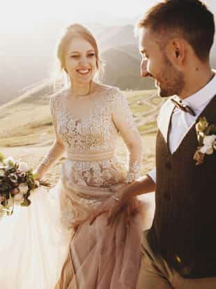 Stylish young wedding couple has fun posing in beautiful Georgian mountains