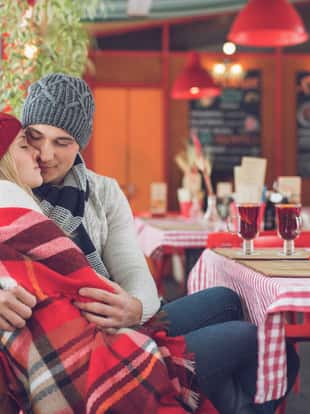 Embracing young couple in a cafe