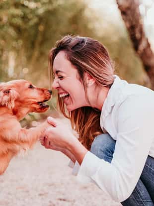 junge Frau und ihr süßer Cockerspaniel-Welpe im Freien in einem Park