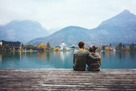 Young Caucasian couple sitting near the lake