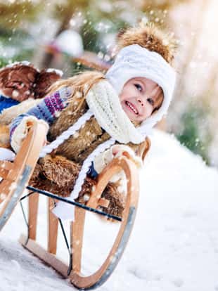 Little girl on sled in winter park