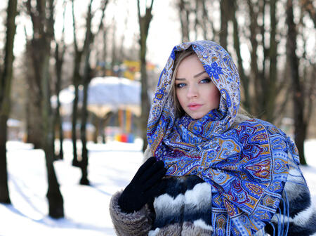 Young beautiful girl with blue eyes posing outdoors. Winter park