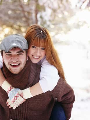 Young couple having fun in snowy winter scene