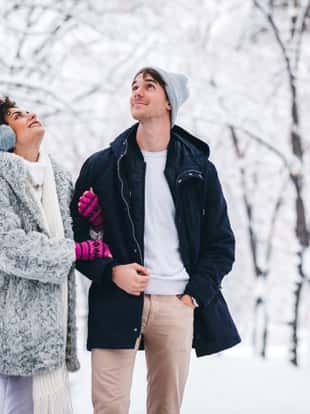 Young couple holding hands and walking in the snow