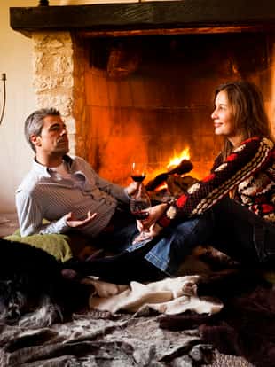 Nice couple and their dog relaxing by the fire.