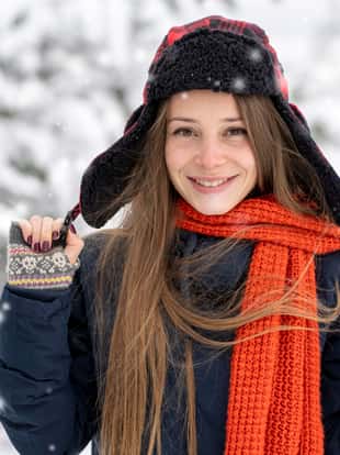 Portrait of a happy and beautiful young woman with woolen cap in winter day