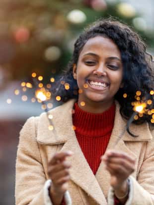 Happy woman at Christmas holding burning sparkler