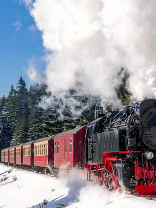 Historical steam train running full speed to Brocken Mountain in Harz region