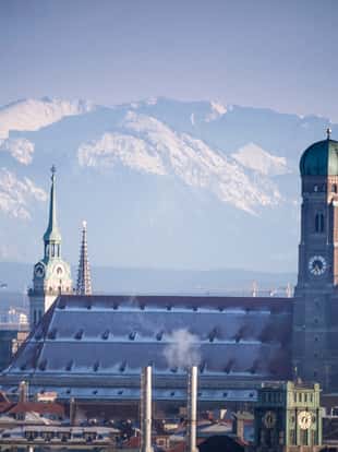 Munich covered in snow in front of the Bavarian Alps.