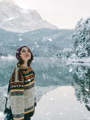 Young Caucasian woman looking at scenic view of Cauma lake in Switzerland in winter