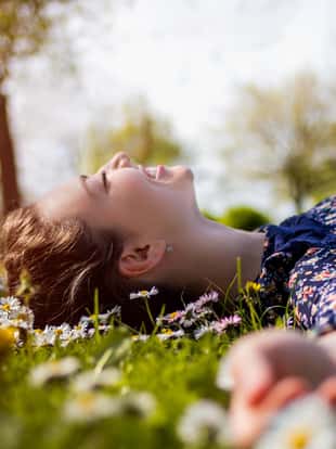 Pretty young teenage girl laying on a grass