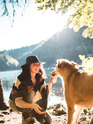 woman playing with the dog in the mountain
