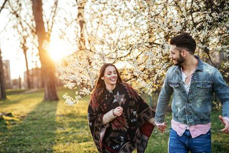 Photo of a happy young couple enjoying in the first signs of spring in the park!