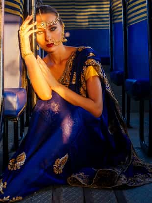 portrait indian beautiful Caucasian woman in traditional blue dress.hindu model with golden kundan jewelry set bindi earrings and nose ring piercing nath fashion photoshoot in bus