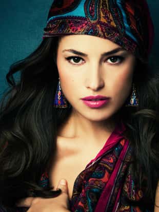 beautiful oriental look young woman with scarf on blue background