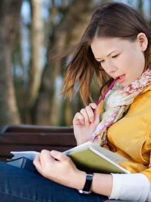 young woman sitting on the bench and reading book
