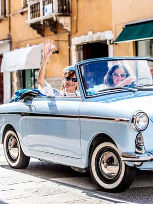 Mature Women Exploring the City with a Vintage Car.