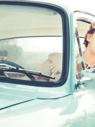 Vintage woman portrait looking outdoors while driving a car