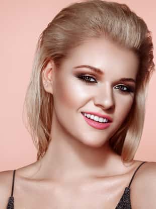 Blonde Girl with Long and Shiny Hair. Beautiful Model Woman with Smooth Hairstyle. Care and Beauty Hair products. Perfect Make-Up. Makeup Look for Parties