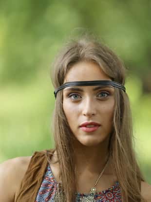 close up. portrait of a young hippie woman on a blurred forest background