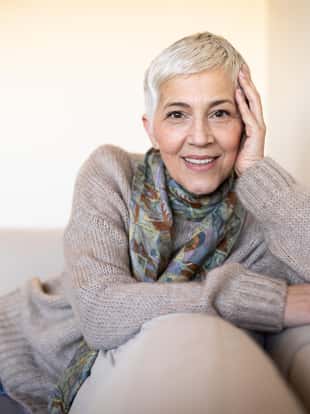 Portrait of a smiling mature woman. Senior female is having short gray hair.