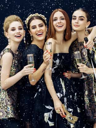 Photo of four laughing girls strewn snow