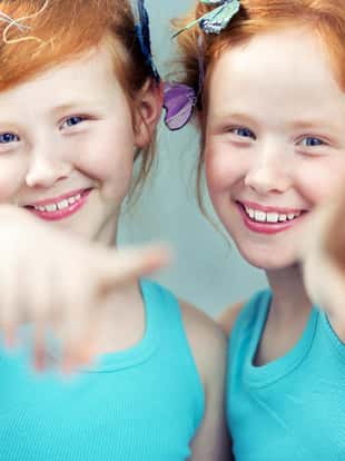 Portrait of two cheerful redhead twin sisters