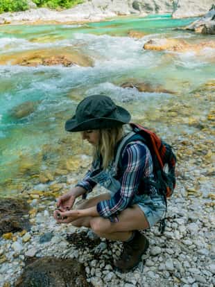 The young woman enjoys the river Soča, Trenta valley, Primorska, Slovenia, Europe,no logos,Nikon D850