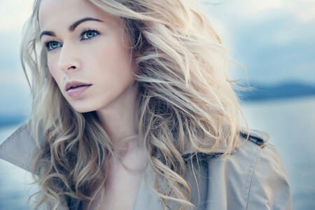 Beautiful young blond woman outdoors portrait near the lake.