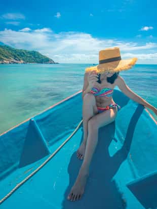 slim woman relax and enjoy the sea by lie sitting down on the the prow of the local ferry boat bow, in holiday and long weekend vacation traveling in summer time