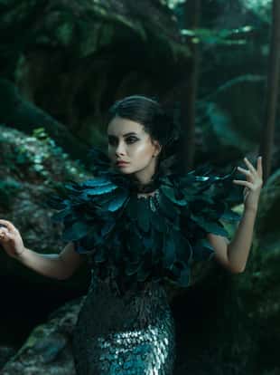 Girl - black raven wanders in the mountains. Gothic photosession theme of Halloween. Unusual, creative outfit