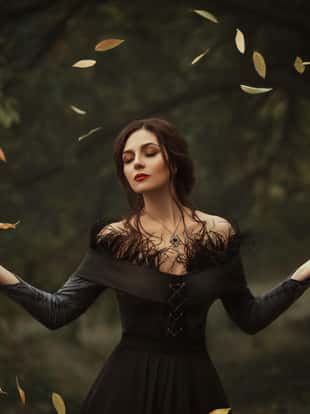 Incredible, amazing, seductive girl, in a dress , magic rotates the leaves. The background is fantastic autumn. Artistic photography.