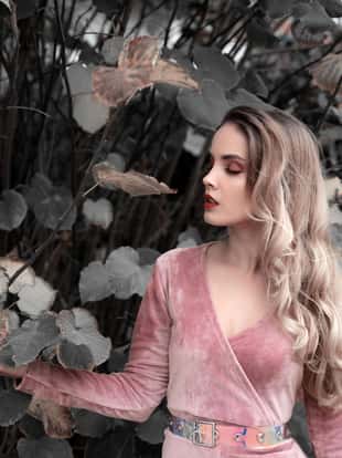 Young sensual woman wearing pink dress in nature