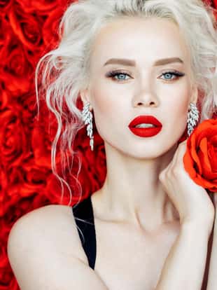 Beautiful girl on a background of red roses