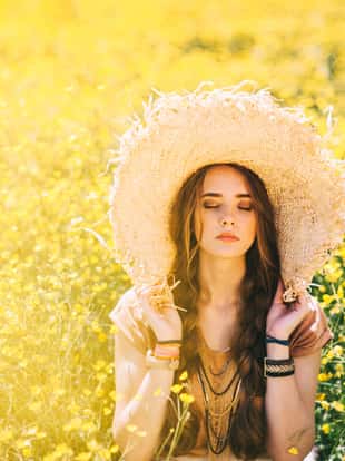 Romantic hippie girl standing in a field. Summer. Hippie style.