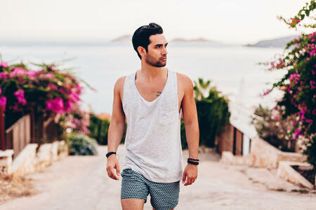 Handsome man wearing casual summer clothes and posing in sea scenery