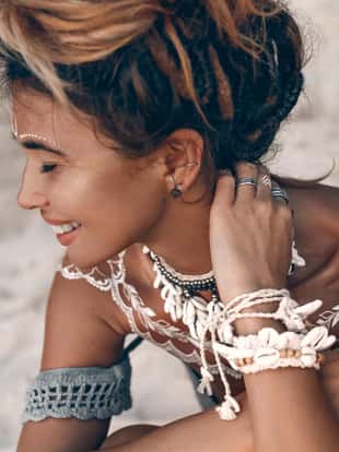 close up of young beautiful boho woman portarait with traditional ornament outdoors at sunset
