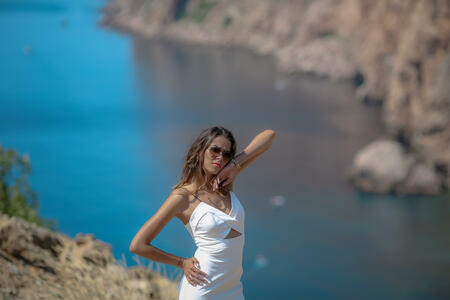 Beautiful woman on top of a mountain on a background of blue sea bay